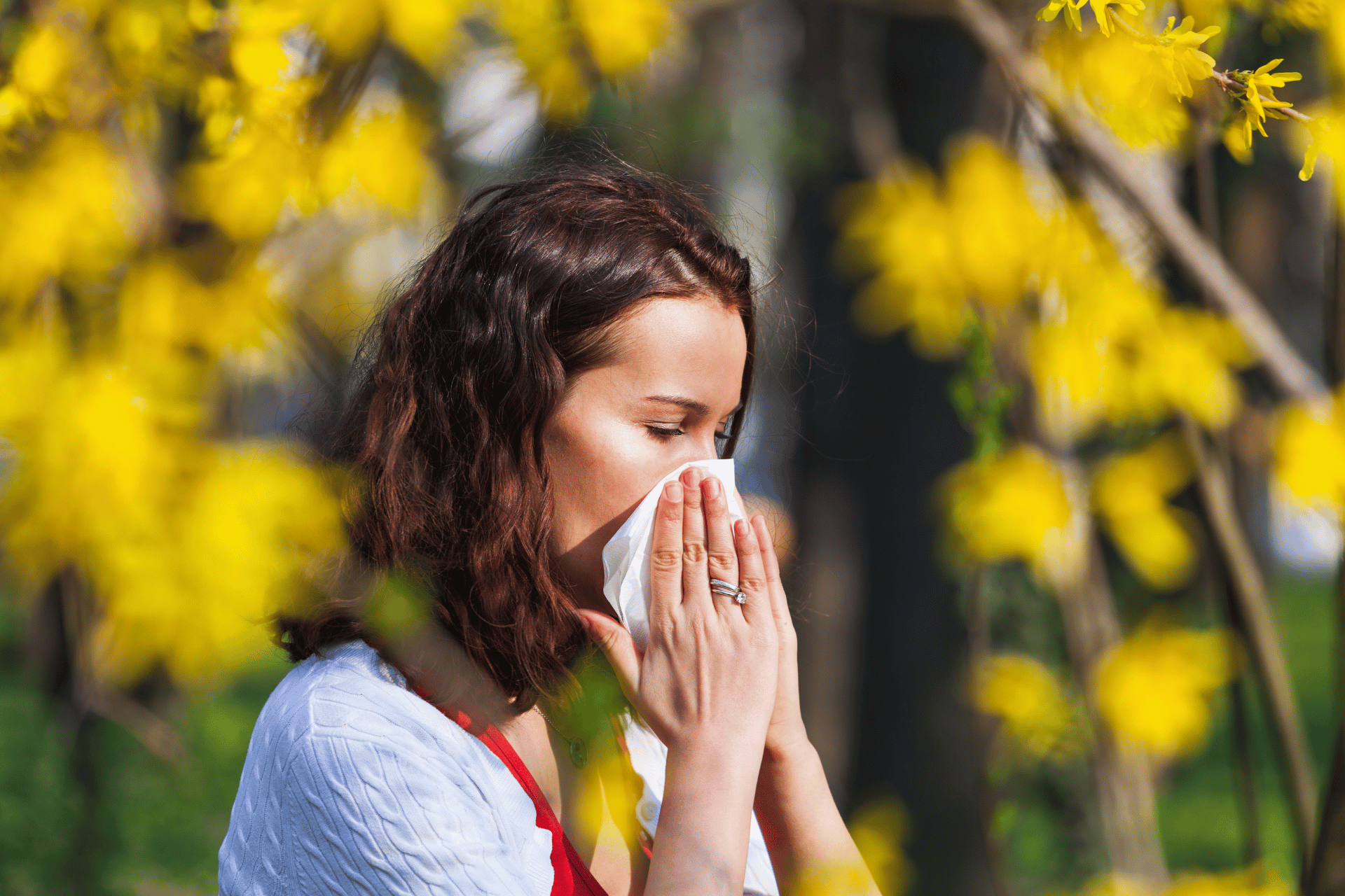 Woman sneezing into tissue